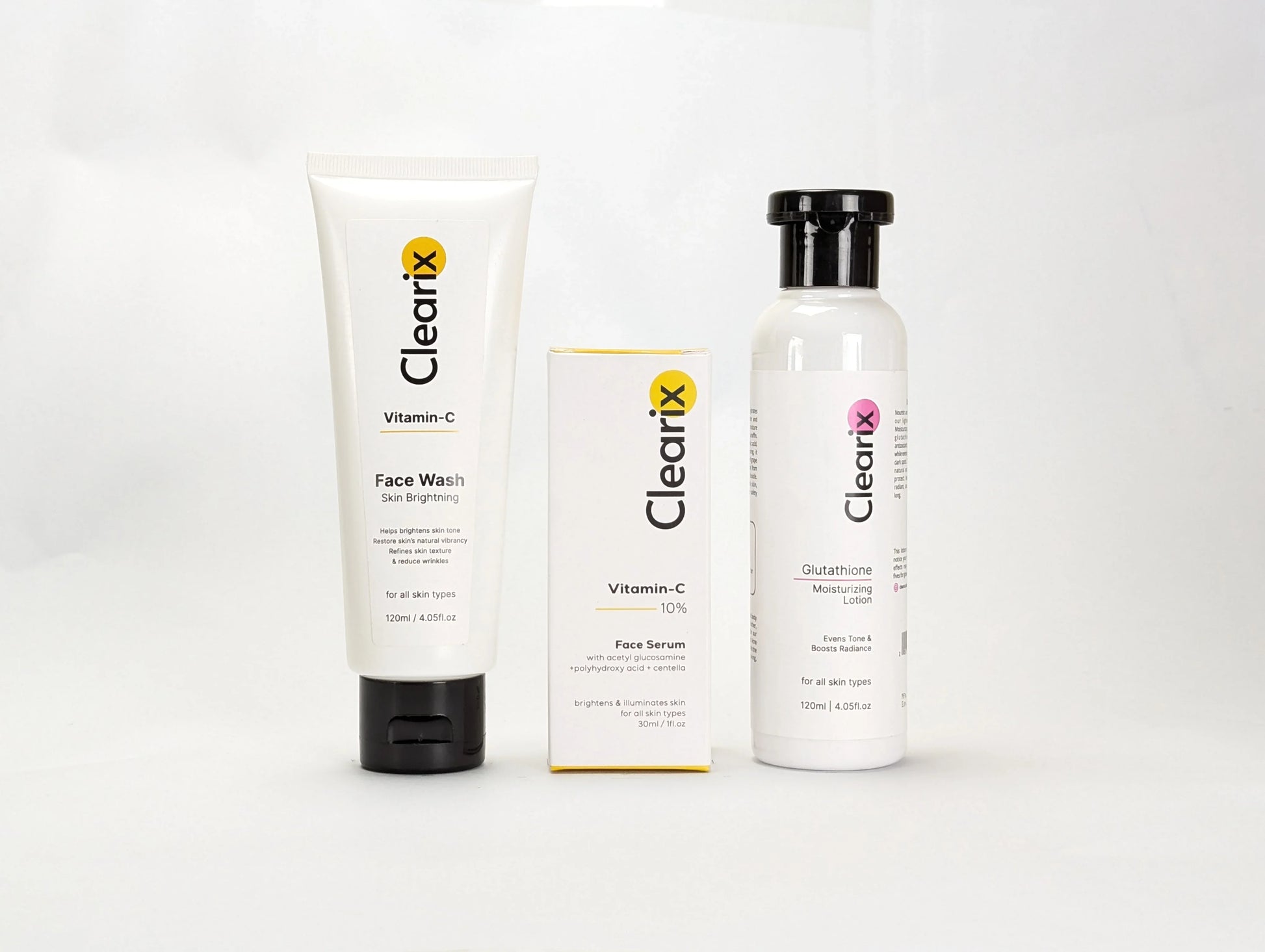 Clearix skincare products displayed against a white background. The image features three items: a Clearix Vitamin-C Face Wash in a white tube for skin brightening, a Clearix Vitamin-C 10% Face Serum in its original yellow and white packaging for enhanced radiance, and a Clearix Glutathione Moisturizing Lotion in a white bottle with a flip-top cap for hydration and even skin tone. Each product is designed to nourish, brighten, and improve overall skin health.