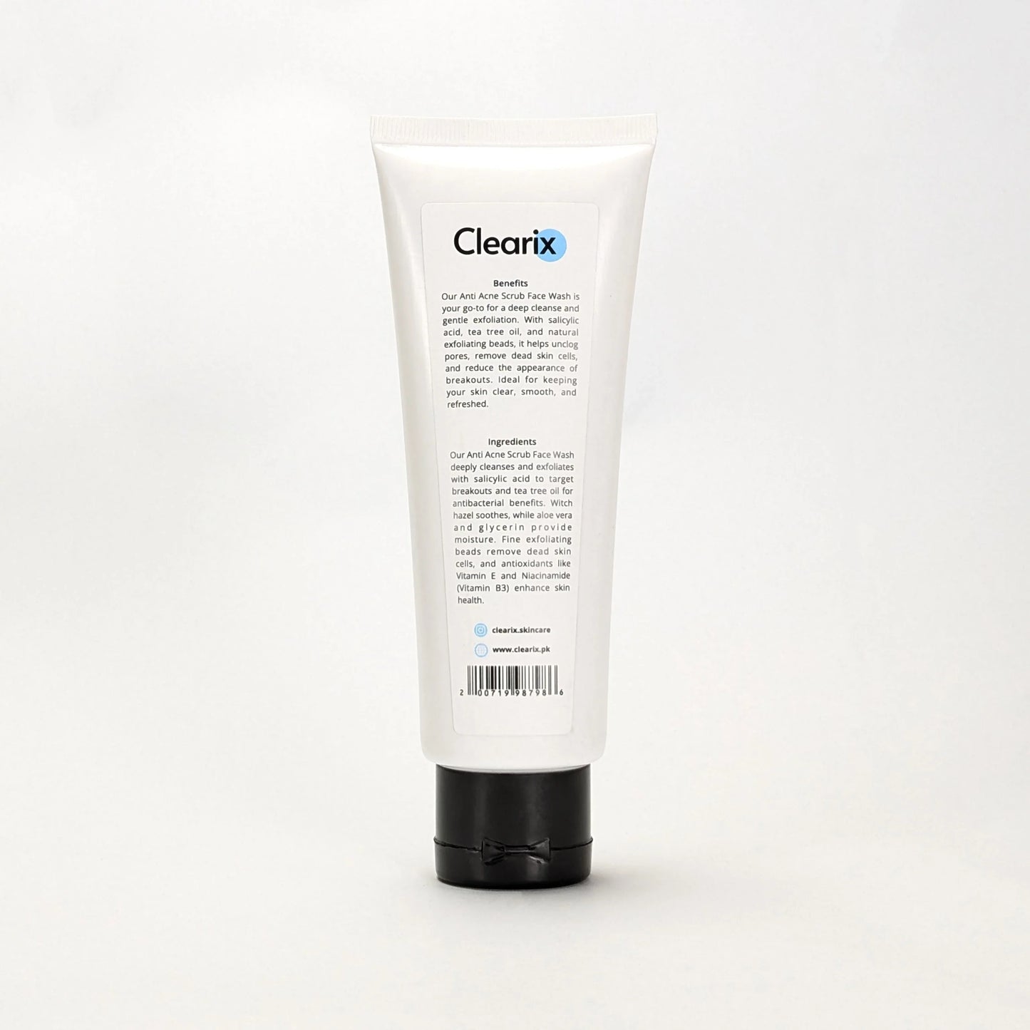 Back view of Clearix Anti Acne Scrub Face Wash tube against a white background. The white 120ml tube with a black flip-top cap displays product benefits and ingredients, highlighting salicylic acid, tea tree oil, and natural exfoliating beads that cleanse, unclog pores, and reduce breakouts. The formula also includes witch hazel, aloe vera, and niacinamide for hydration and skin health.