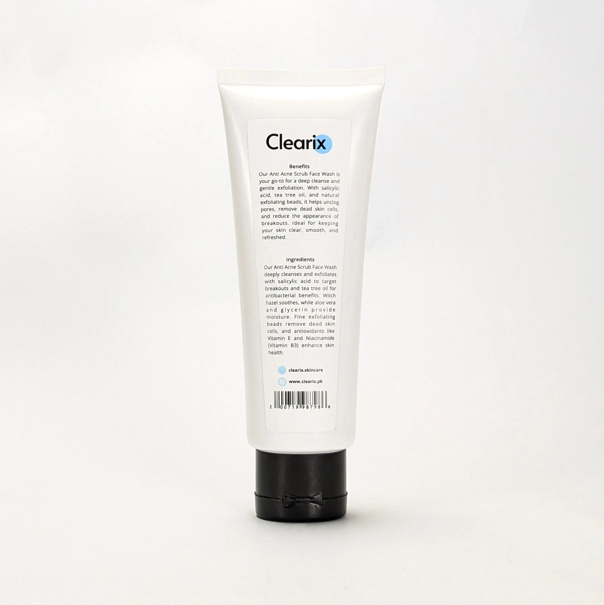Back view of Clearix Anti Acne Scrub Face Wash tube against a white background. The white 120ml tube with a black flip-top cap displays product benefits and ingredients, highlighting salicylic acid, tea tree oil, and natural exfoliating beads that cleanse, unclog pores, and reduce breakouts. The formula also includes witch hazel, aloe vera, and niacinamide for hydration and skin health.