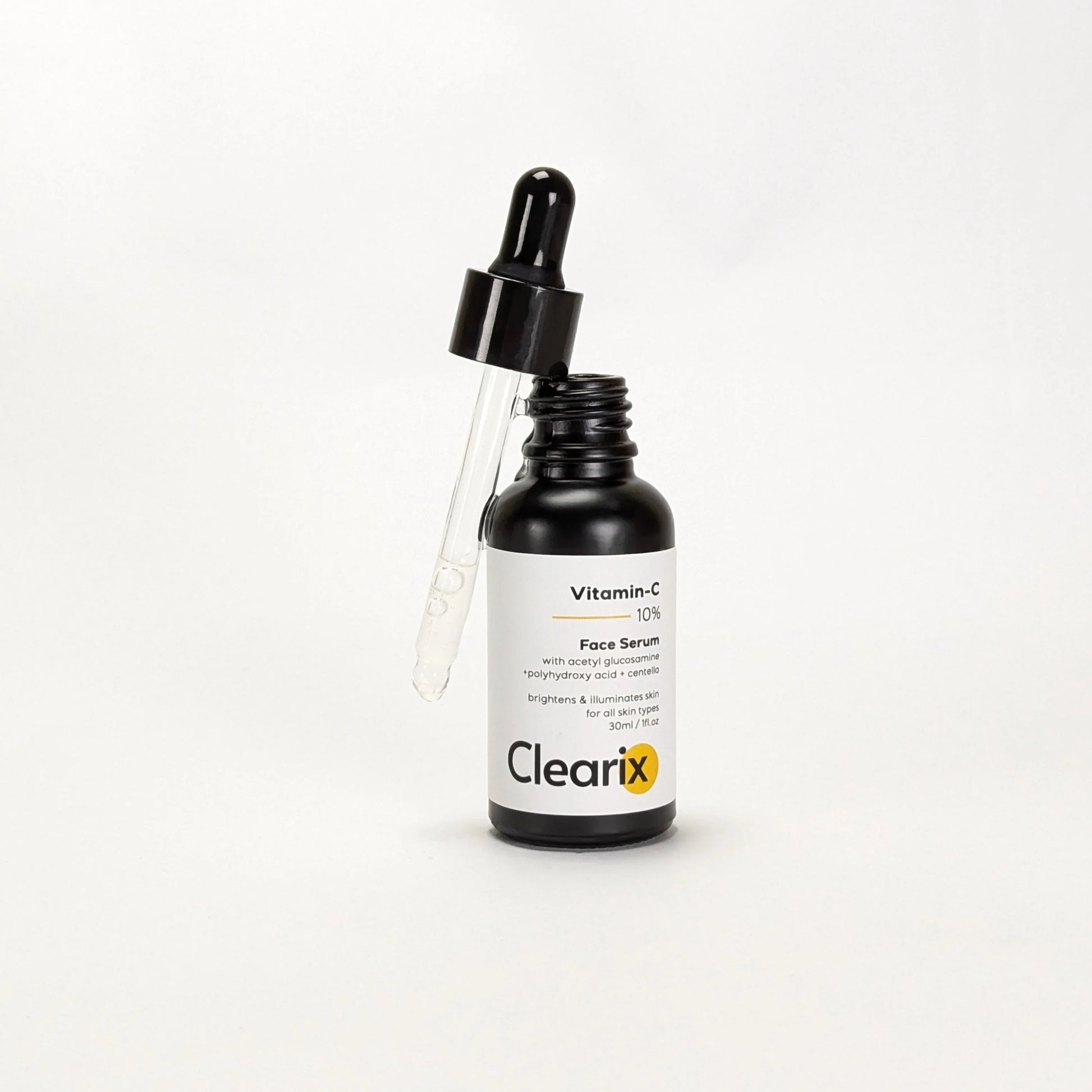 Clearix Vitamin-C 10% Face Serum displayed against a white background. The image features a 30ml black dropper bottle with the dropper lifted, showing the serum inside. Formulated with acetyl glucosamine, polyhydroxy acid, and centella, the serum helps brighten and illuminate the skin. Suitable for all skin types.