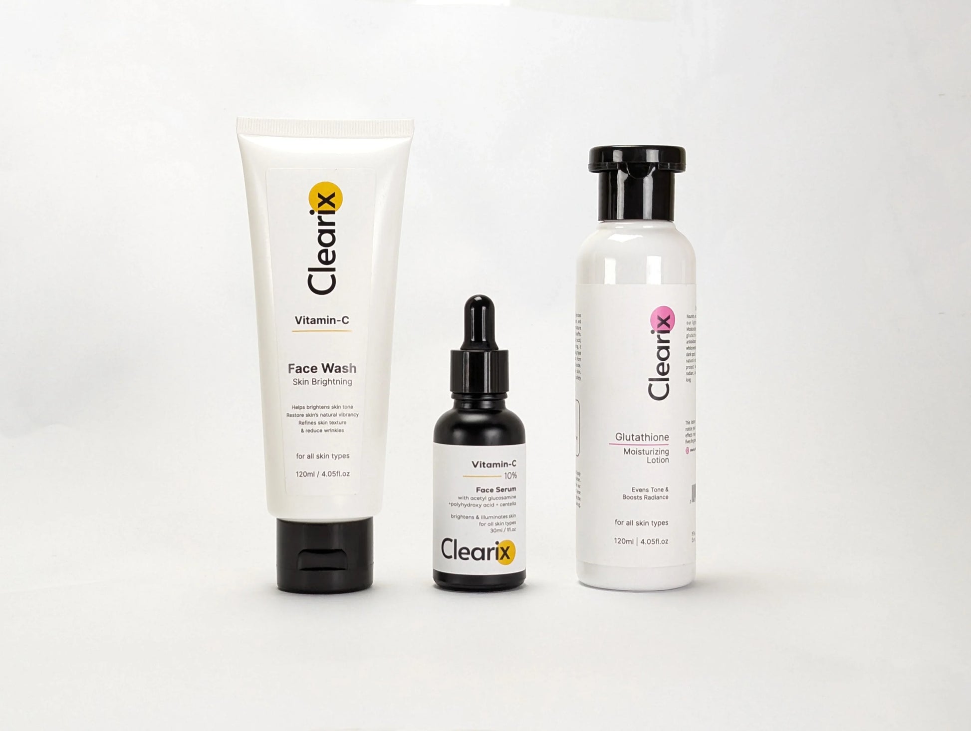 Clearix skincare products displayed against a white background. The image features three items: a Clearix Vitamin-C Face Wash in a white tube for skin brightening, a Clearix Vitamin-C 10% Face Serum in a black dropper bottle for enhanced radiance, and a Clearix Glutathione Moisturizing Lotion in a white bottle with a flip-top cap for hydration and even skin tone. Each product is formulated to nourish, brighten, and improve overall skin health.